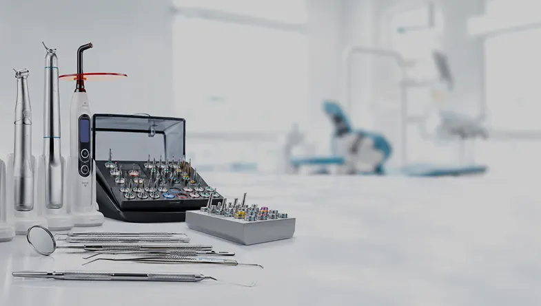 Instruments dentaires haut de gamme et équipements cliniques professionnels comprenant kits d’implantologie, pièces à main, lampes à photopolymériser, miroirs et sondes dentaires dans un showroom médical moderne.
